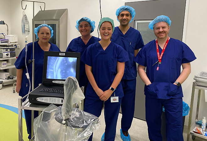 surgical team standing and smiling in operating room | Vision Hospital Group