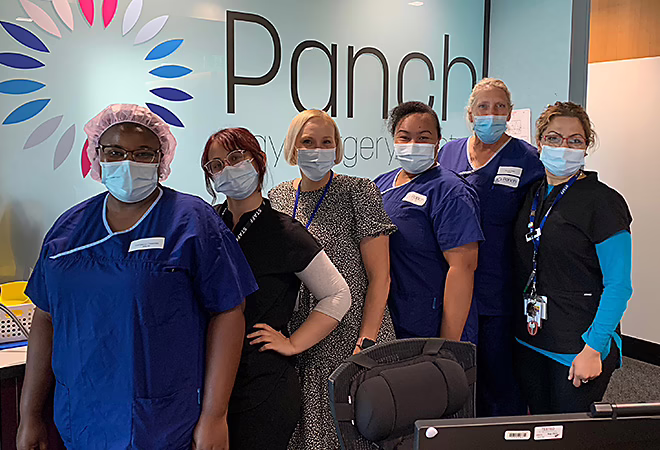 Panch nursing staff wearing masks in front of reception desk
