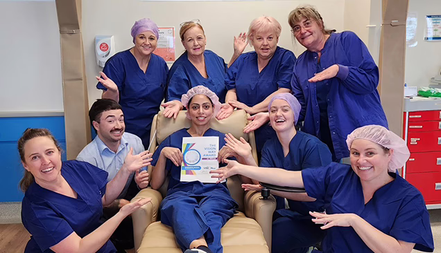 Windsor Gardens Nurse and winner of The Vision Way Award, Sherreen Jassal sitting on a chair with her award surrounded by her team