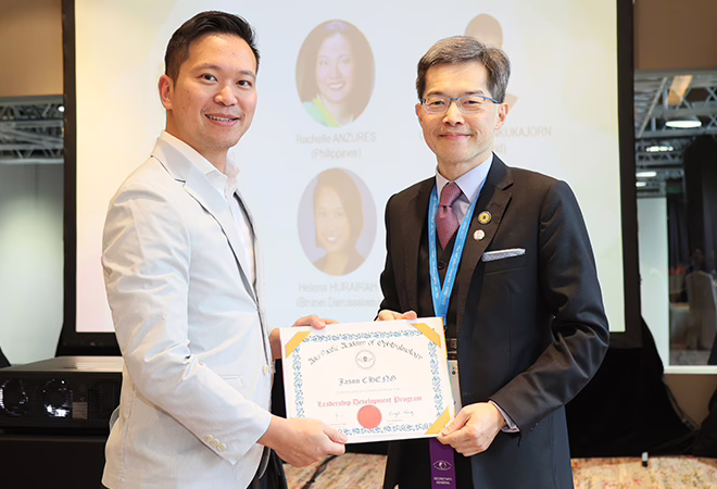 An image of Dr Jason Cheng holding an award at the APAO 2023 Congress in Malaysia.